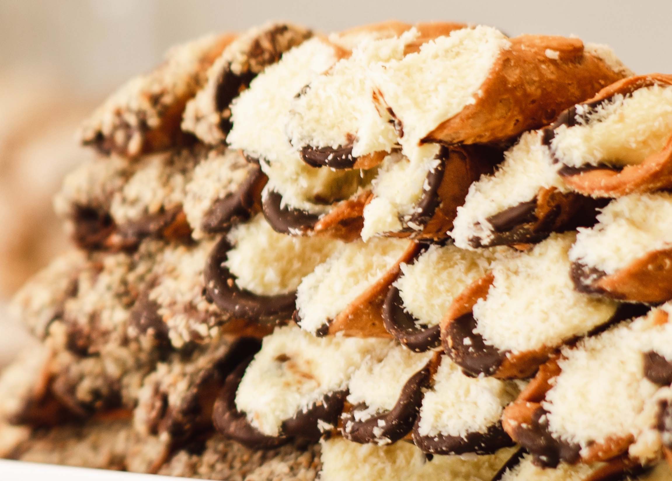 Chocolate cannolis stacked high stuffed with chocolate and cannoli cream with drizzed chocolate on top