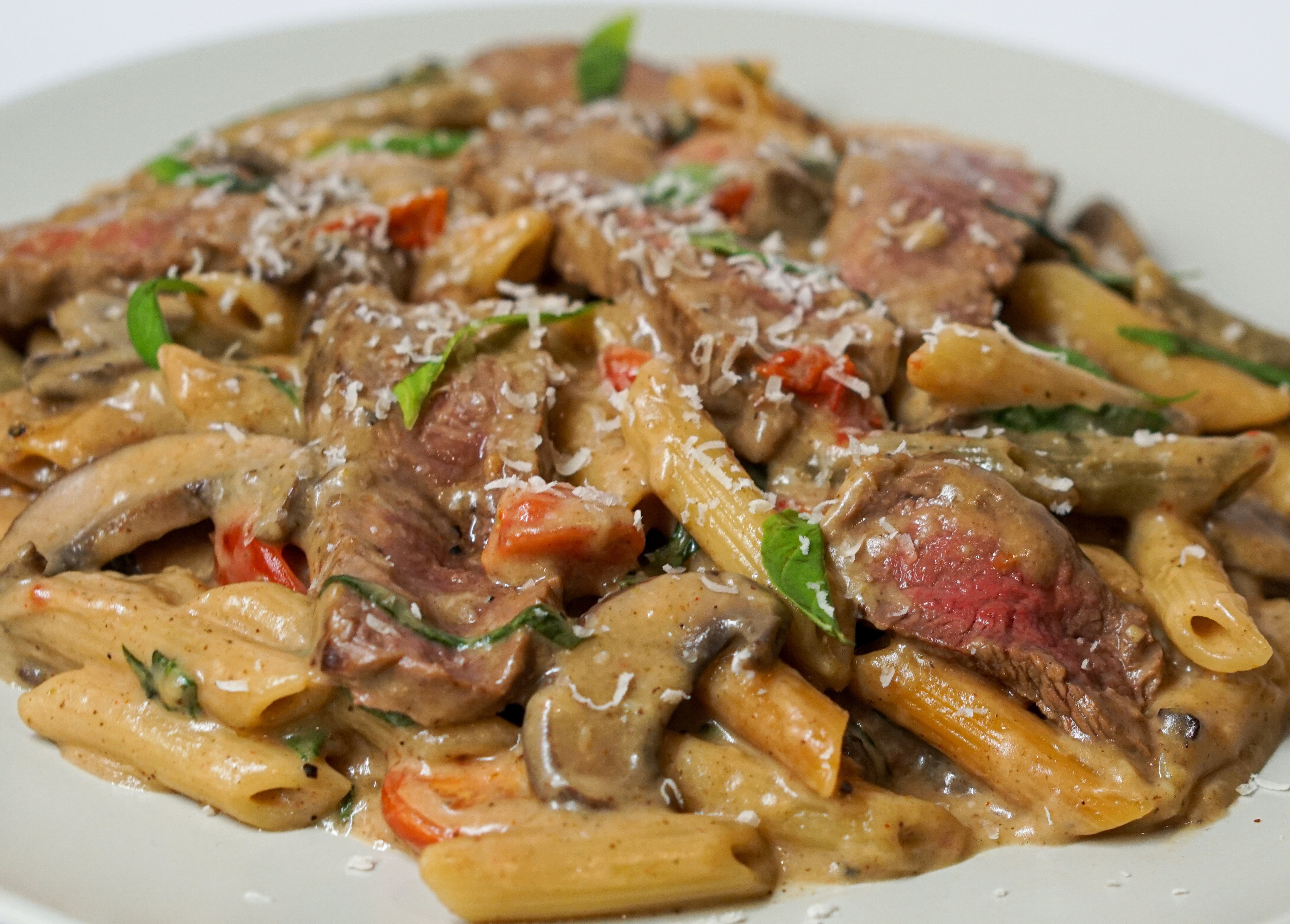 Spicy sausage piled on a bed of pasta and tomatoes
