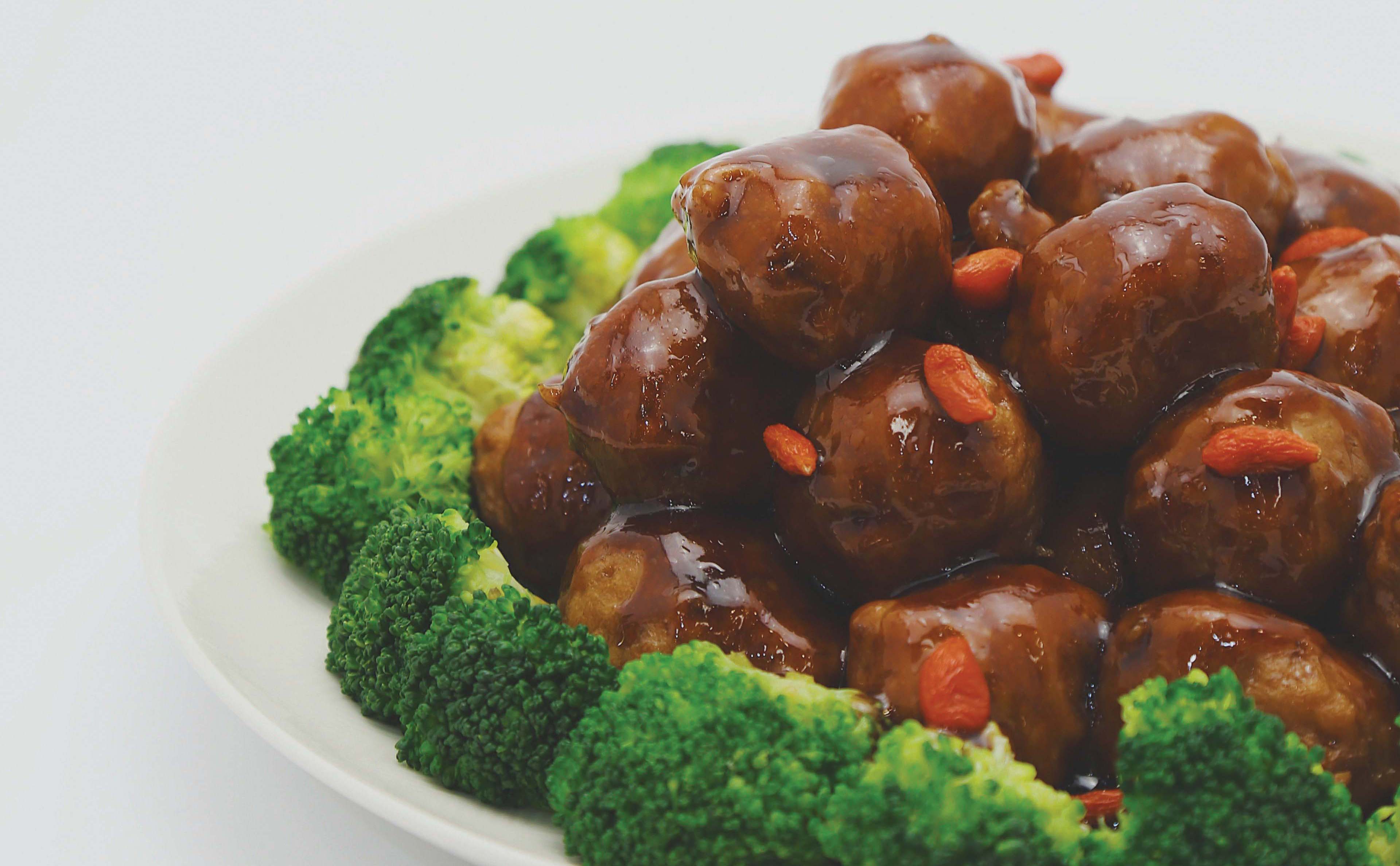 Saucy meatballs served with carrot coins and broccoli